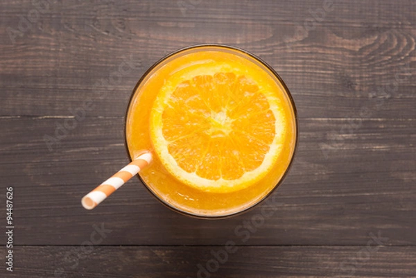 Obraz Fresh orange juice in glass on wooden background