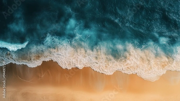 Fototapeta Aerial view of turquoise ocean waves gently crashing onto a pristine sandy beach during bright daylight