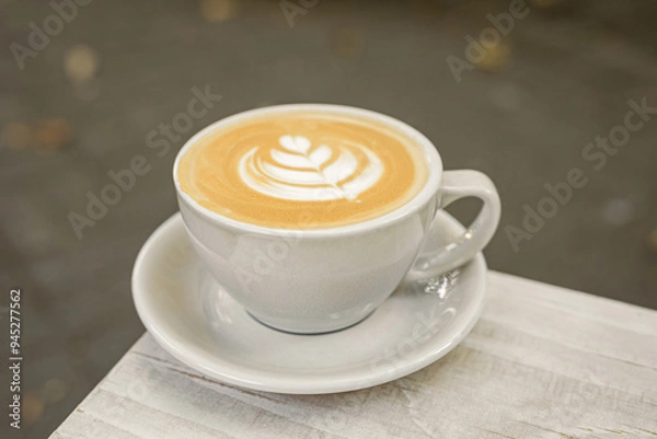Fototapeta A cup of cappuccino on the table outside