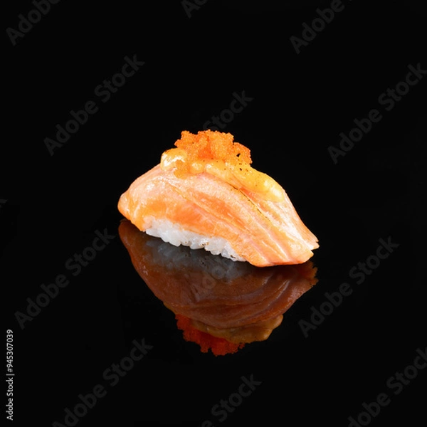 Fototapeta Close-up of a delectable salmon nigiri sushi garnished with a delicate topping, isolated on a dark background