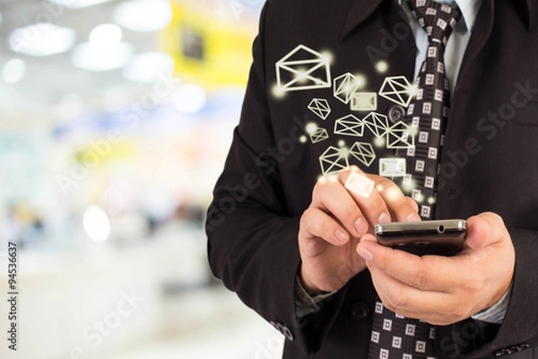 Fototapeta Business woman sending email by using mobile phone.