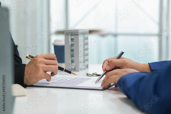 Fototapeta Real estate agent is talking to customer to present promotion for signing contract buy and selling real estate in company project in real estate office. present promotion to make customer decide buy.