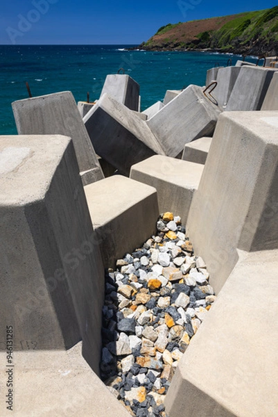 Fototapeta stone barriers on wharf at coffs harbour on nsw north coast of australia with blue water and sky
