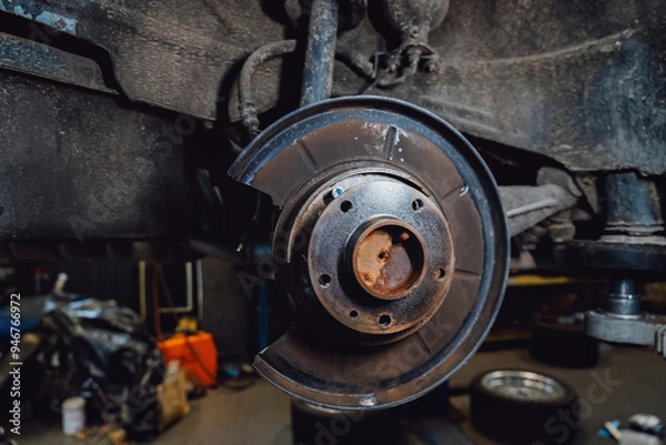Obraz The rim is removed showing the rotor and caliper. Disc brake on car in process of new tire replacement