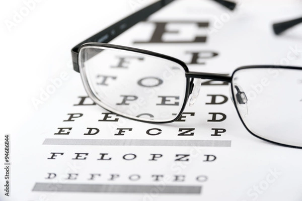 Fototapeta Eye glasses on eyesight test chart background close up