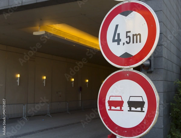 Fototapeta An image of a warning sign telling that the tunnel is 4,5 meters high and passing by is prohibited. The warning signs has been composed to the right side of the image.