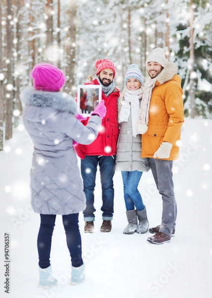 Obraz smiling friends with tablet pc in winter forest