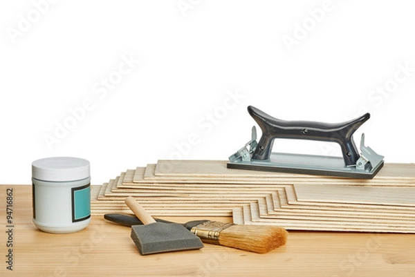 Obraz sandpaper holder, stack of veneers and paint brushes