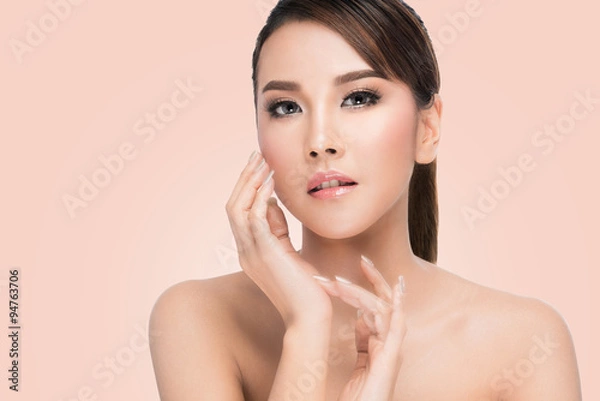 Obraz Spa Woman Portrait. Beautiful Asian Girl Touching her Face. Perfect Fresh Skin. Pure Beauty Model Female looking at camera. Youth and Skin Care Concept.on pink background with clipping path.