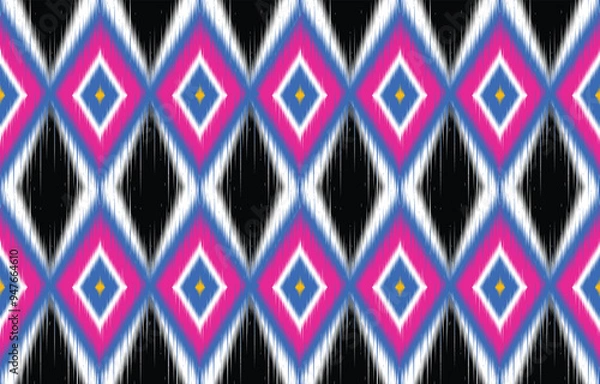 Fototapeta Vibrant ikat pattern seamless background. Colorful ethnic design with diamond shapes. Trendy boho chic textile print. Geometric ikat motif in blue, pink, and white. Modern ikat wallpaper. 