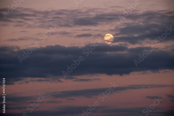 Fototapeta Milky moon in cloudy sky at sunset