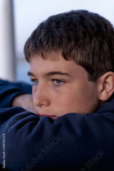 Fototapeta Pensive child looking through a window