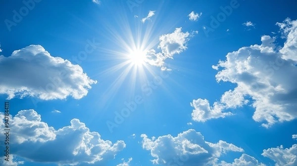 Fototapeta Clear blue sky with a few white clouds, serene weather, bright sunlight