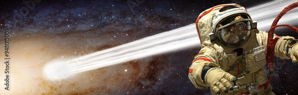 Fototapeta A cosmonaut has a comet pass close to him - Elements of this image furnished by NASA.