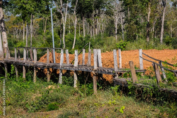 Obraz An old wooden bridge stretches across the fields.