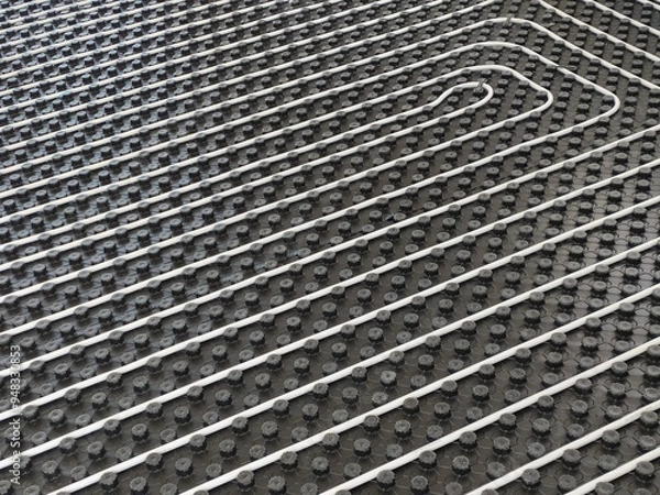 Fototapeta A detailed image of a radiant floor heating system being installed, showing pipes, insulation, and layout.