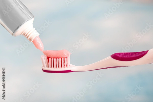 Fototapeta Toothbrush and toothpaste, squeezing toothpaste from tube onto toothbrush close-up. Daily oral care after meals concept.