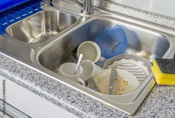 Obraz A small pile of dirty dishes in a kitchen sink