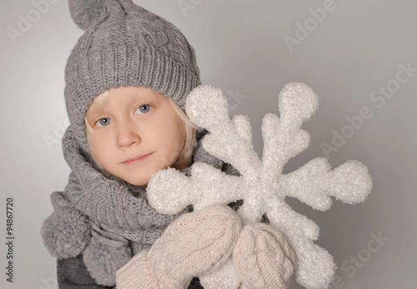 Fototapeta warmly dressed boy holding a flake of snow