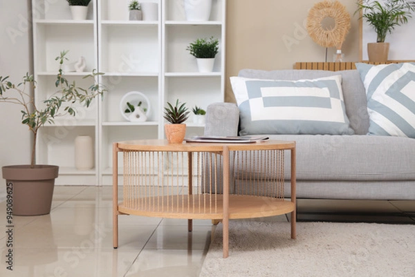 Fototapeta Interior of stylish living room with comfortable sofa, coffee table, shelving unit and houseplant