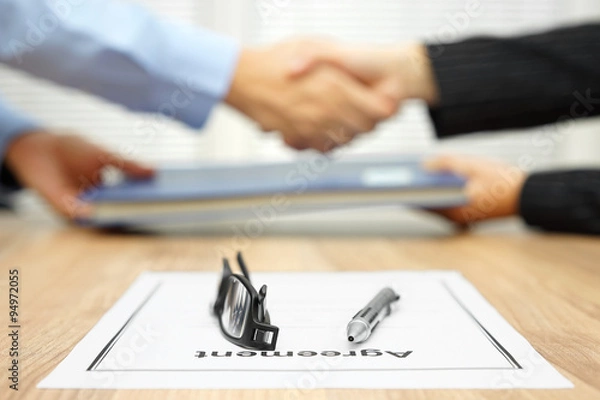 Fototapeta businessman and businesswoman are shaking hands and exchanging f