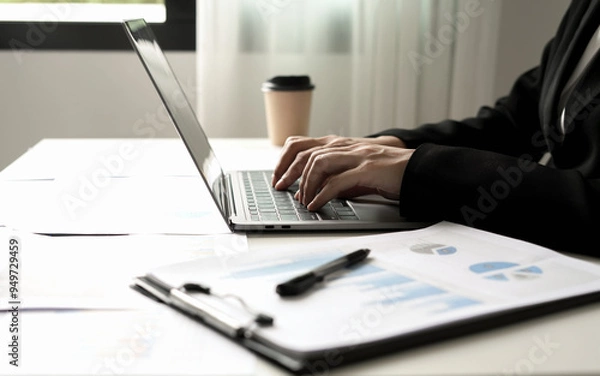 Fototapeta Asian businesswoman sit at their desks and calculate financial graphs showing results about their investments and plan successful business growth process