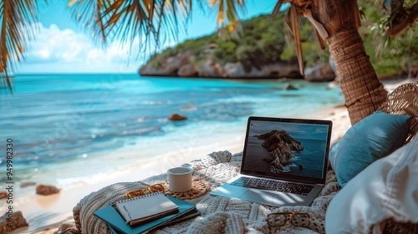 Obraz A remote worker having a virtual meeting while sitting on a beach towel, with the ocean waves rolling 
