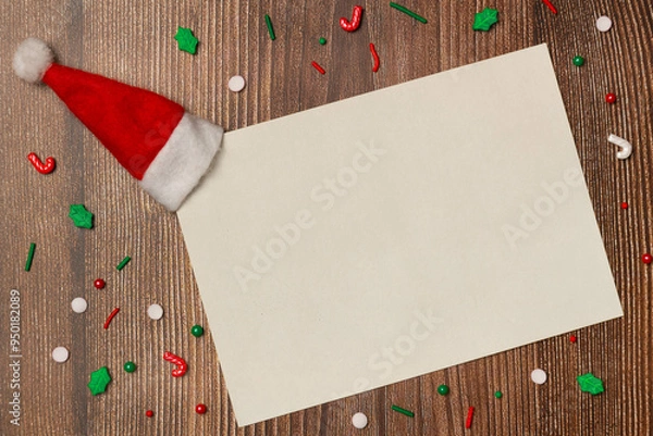 Fototapeta Empty white paper with candies on wooden background from above. Flat lay, top view. Space for text.