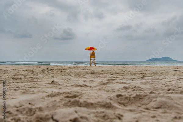Fototapeta Beach lifeguard in the middle of the beach on a cloudy day and no people on the sea. Tombo beach, Guaruja - SP, Brazil.