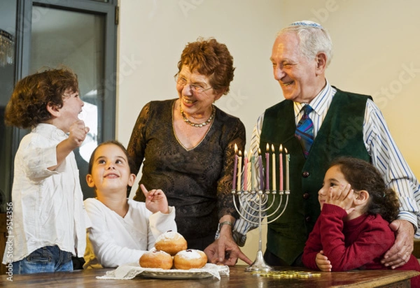 Obraz dziadkowie i wnuki wspólnie zapalają Chanukę