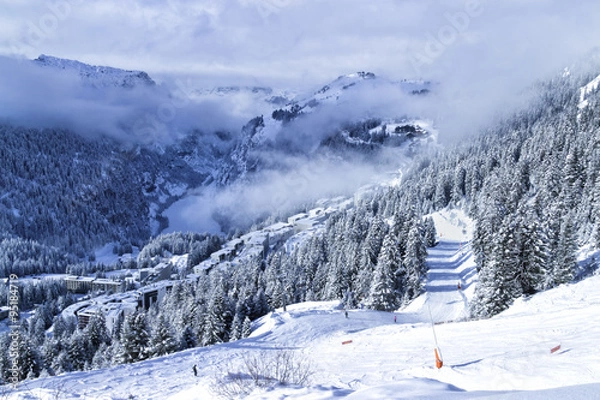 Obraz Widok z góry na francuski ośrodek narciarski Flaine w Grand Massive w Alpach z domkami, blokami mieszkalnymi, lasem sosnowym i stokami w mglisty zimowy dzień