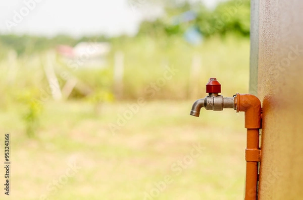 Obraz Outside faucet with orange pipe