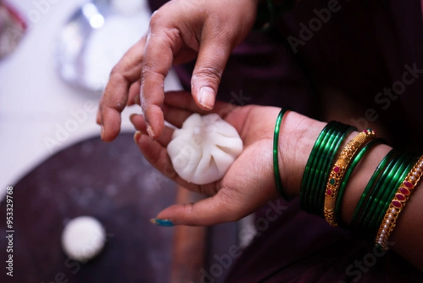 Fototapeta Woman making sweet rice modak stuffed with grated coconut and jaggery