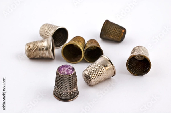 Fototapeta Old fashioned thimbles on white background with selective focus