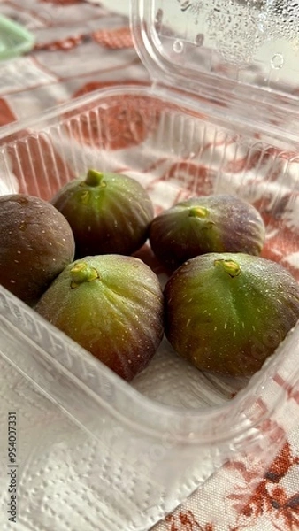 Fototapeta fichi in vaschetta trasparente su tavolo.