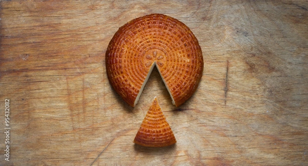 Fototapeta Home smoked rustic cheese on kitchen board.