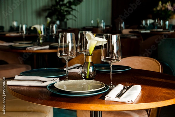 Fototapeta Stylish table setting in a cozy restaurant with dishes and furniture.in a minimalist style