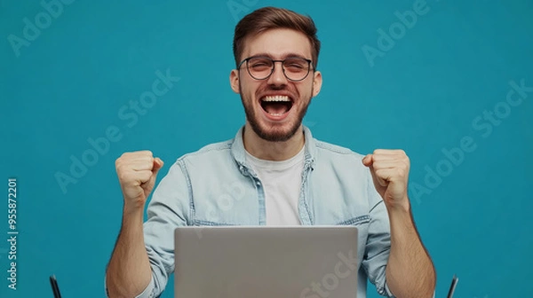 Fototapeta A happy smilling man with glasses and a laptop celebrating his success. Generative AI	