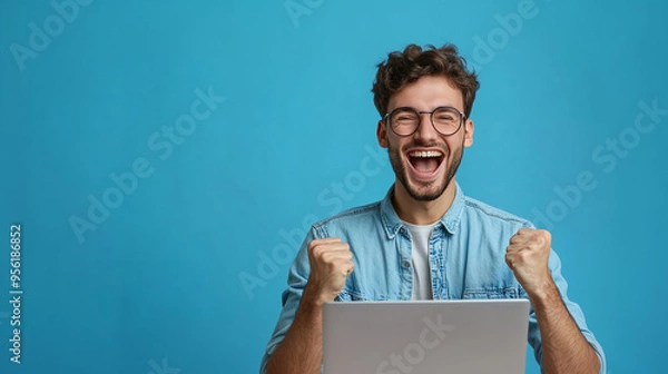 Fototapeta A happy smilling man with glasses and a laptop celebrating his success. Generative Ai