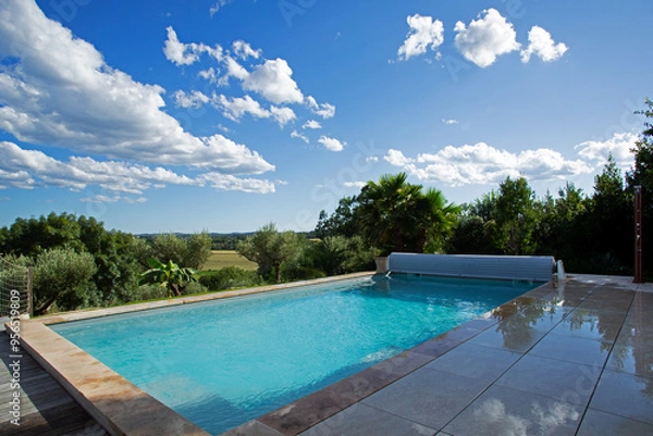 Fototapeta Piscine de luxe d'une villa de vacances arborée dominant la plaine et la forêt d'un magnifique lieu de tranquillité dans le sud de la France en été.