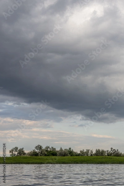 Fototapeta Clouds and rain over the river