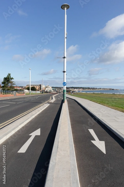 Fototapeta White arrows showing direction of travel painted on cycle paths in seaside location
