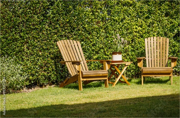 Obraz Two wooden chairs and a table in a garden