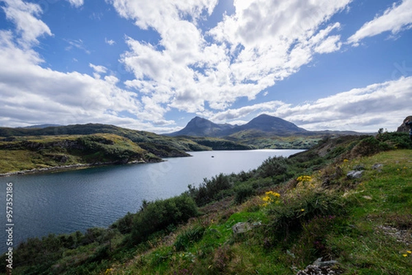 Fototapeta The image shows a body of water surrounded by hills in Loch a' Chàirn Bhàin, Scotland. The scene includes clouds, nature, water, sky, mountains, and a highland landscape.