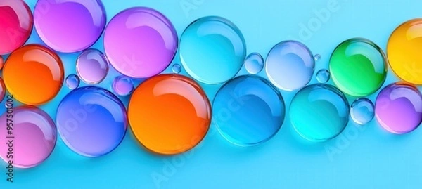 Fototapeta A vibrant arrangement of colorful translucent bubbles on a smooth blue surface, creating a modern desktop wallpaper.