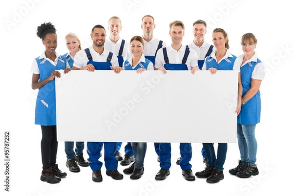 Fototapeta Happy Multiethnic Janitors Holding Blank Billboard