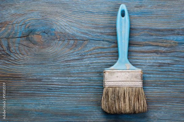 Obraz Used paint brush on blue wooden board with place for text