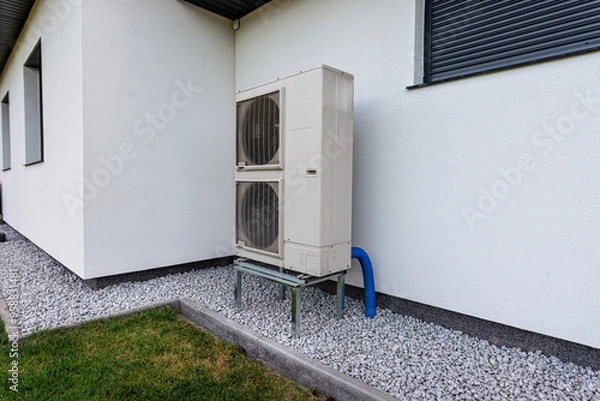 Obraz Two efficient outdoor heat pump units placed in front of the house.