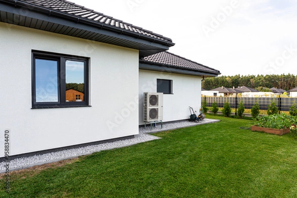 Obraz Two efficient outdoor heat pump units placed in front of the house.