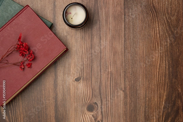 Fototapeta Books with flowers and candle on wooden background from above. Flat lay, top view.